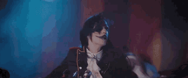 a man in a black suit and white shirt is dancing on a stage .