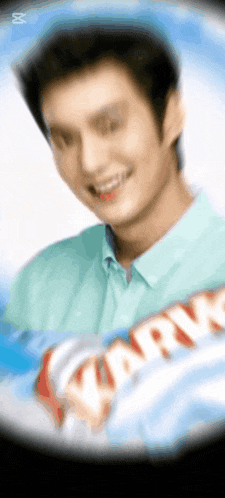 a man in a green shirt is smiling in front of a sign that says ' karry ' on it