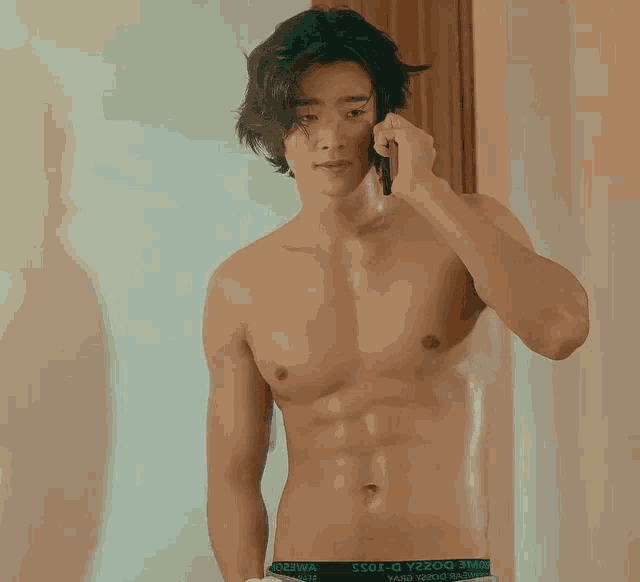 a shirtless man is talking on a cell phone while wearing a pair of boxer briefs that say dolce & gabbana