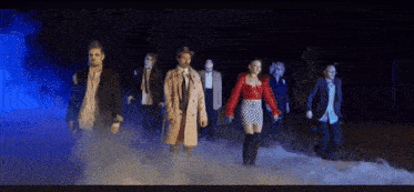 a group of people dressed up as zombies are walking through fog