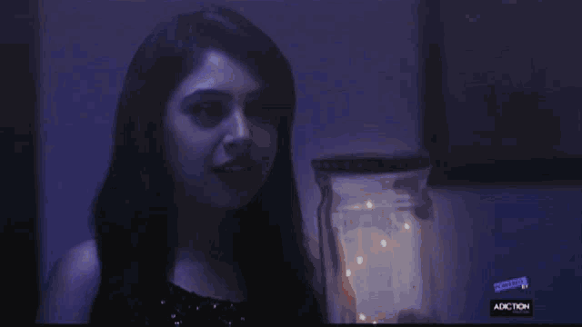 a woman in a black dress stands in front of a jar that has the number 10 on it