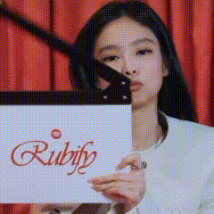 a woman is holding a piece of paper that says ruby on it .