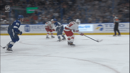 a hockey player with the number 14 on his jersey stands on the ice holding a stick