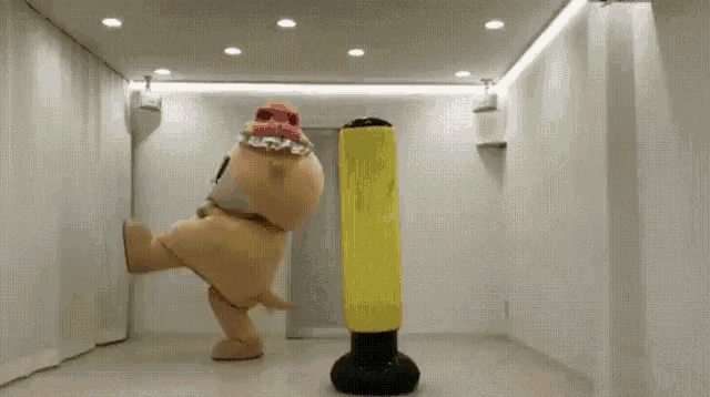 a teddy bear in a pink hat is kicking a punching bag .