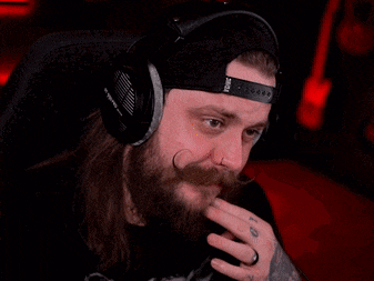 a man with a beard wearing headphones and a hat .