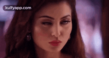 a close up of a woman 's face with red lipstick making a funny face .