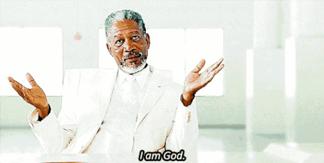 a man in a white suit and tie is saying i am god