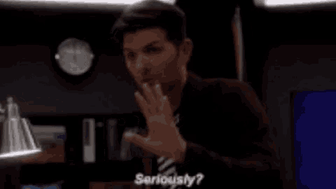 a man in a suit and tie is making a gesture with his hand and says `` seriously '' .