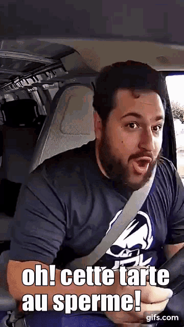 a man with a beard is sitting in the back seat of a car and says oh cette tarte au sperme