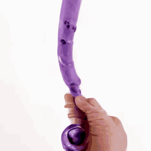 a person is holding a purple object that looks like an octopus