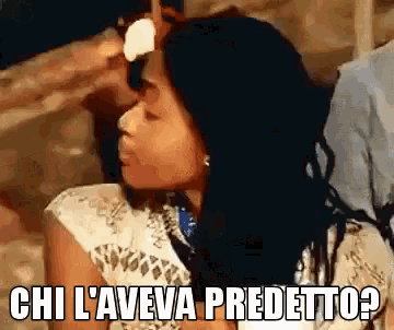 a woman with long black hair is holding a fan and says chi l' aveva predetto ?