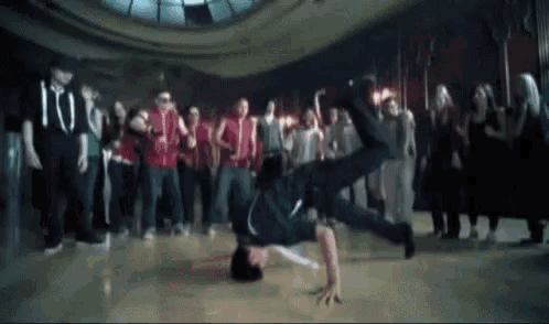 a man is doing a handstand in front of a group of people