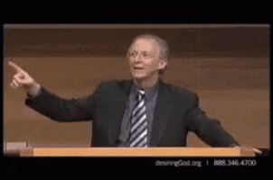 a man in a suit and tie is giving a speech at a podium