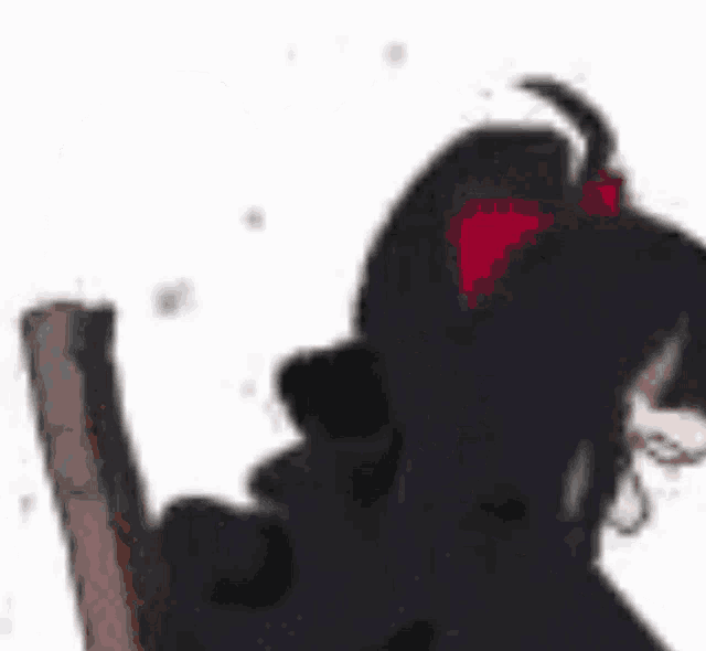 a blurry picture of a girl with a ponytail and a red bow in her hair .