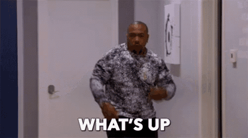 a man is standing in a hallway and says `` what 's up '' .