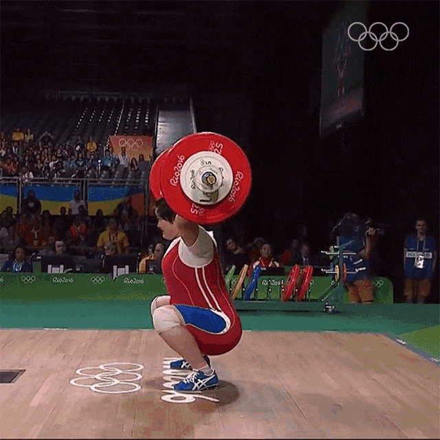 a weightlifter is squatting down while holding a barbell that says rio 2016 on it