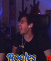 a man wearing ear buds and a black shirt with the word rooles on it