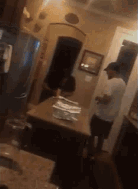 a man in a white shirt is standing in front of a table