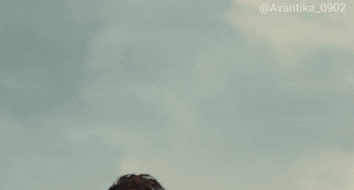 a man with long hair and a beard looks up at the sky with the hashtag avantika_0902