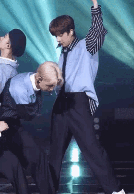 a man in a blue vest and tie is dancing on a stage