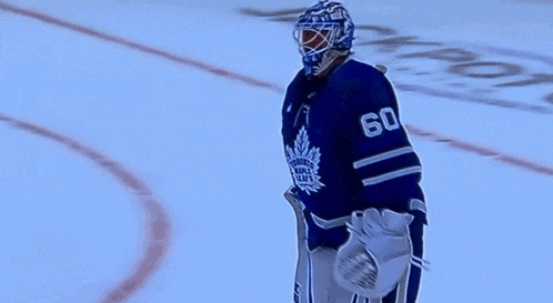 a hockey player with the number 60 on his jersey talks to another player