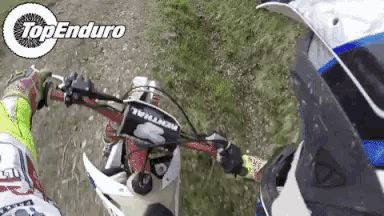 a person is riding a dirt bike with the words top enduro on the bottom