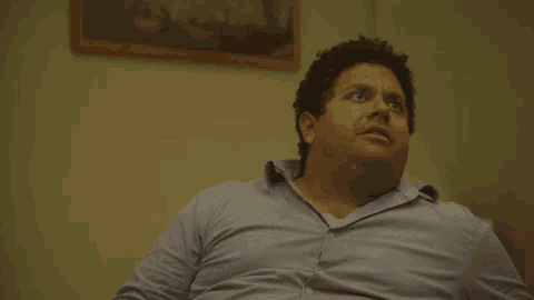 a man in a blue shirt is looking up at the sky