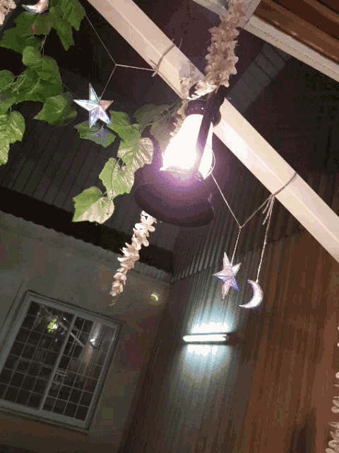 a lantern hanging from the ceiling with a crescent moon and star decorations