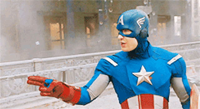 a man in a captain america costume is pointing to something