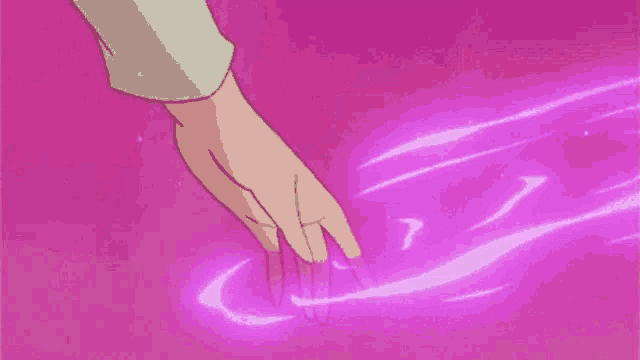a person 's hand is touching a pink surface with a purple glow coming out of it .