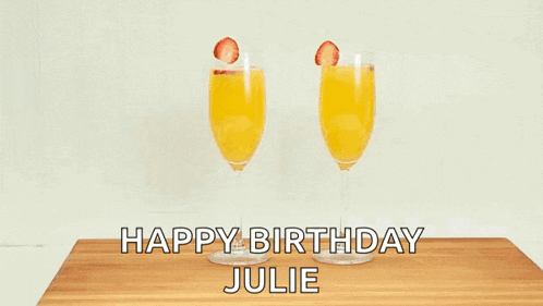 two people are holding glasses of orange juice with strawberries and the words happy birthday julie on the bottom