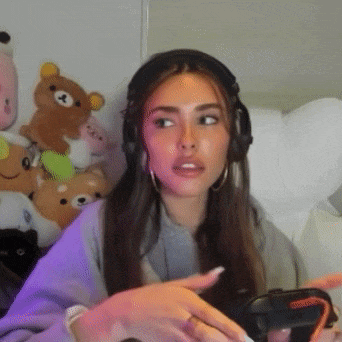 a woman wearing headphones is sitting in a chair in front of stuffed animals .