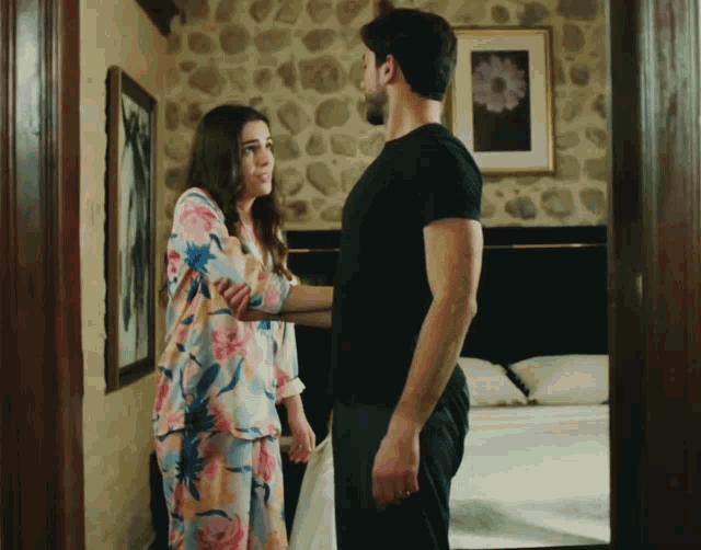 a man and a woman standing next to each other in a room