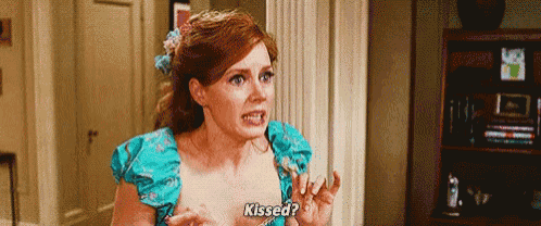 a woman in a blue dress is standing in a room and talking to someone .
