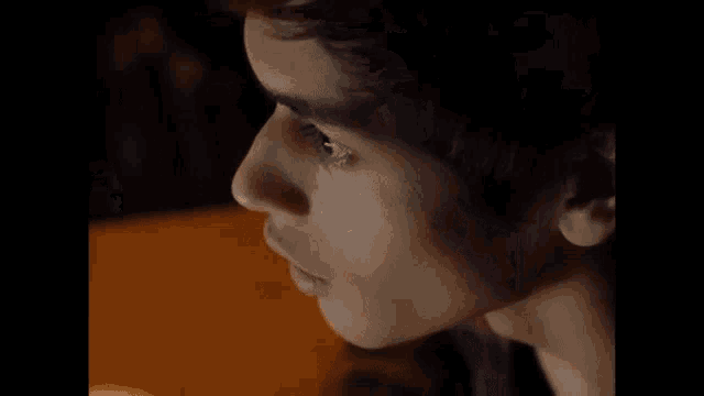 a woman is looking at a man 's face on a screen .