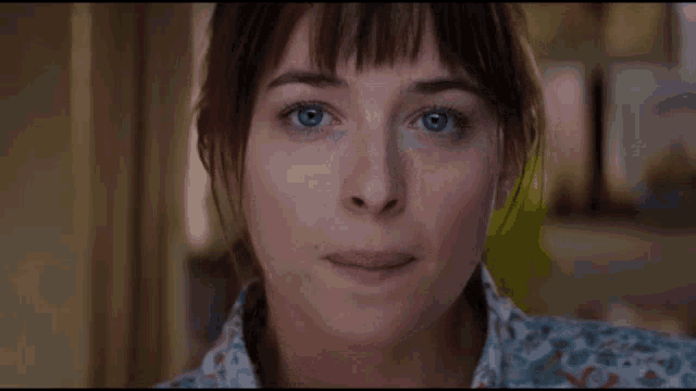 a close up of a woman with blue eyes making a face