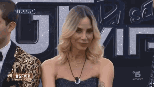 a woman stands in front of a screen that says #gfvip