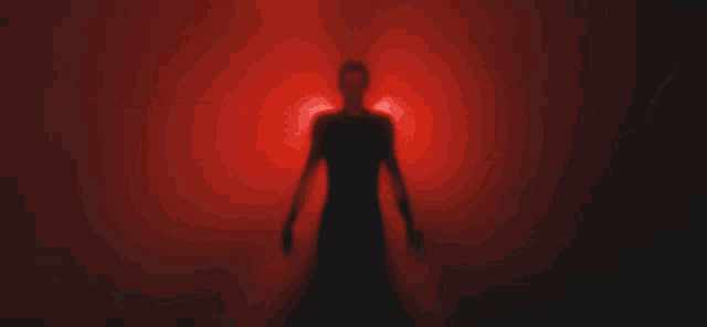 a man in a black shirt is surrounded by red light