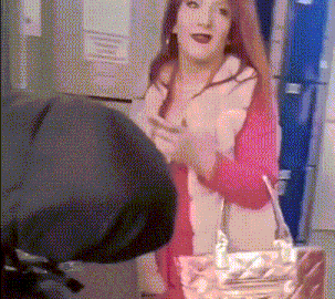 a woman with red hair is holding a purse and talking to someone