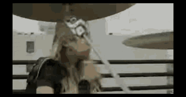 a woman is playing drums in a band while wearing a wizard hat .