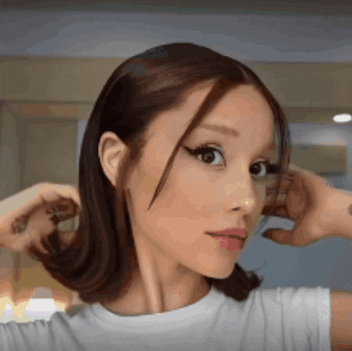 a close up of a woman 's face with her hand on her ear