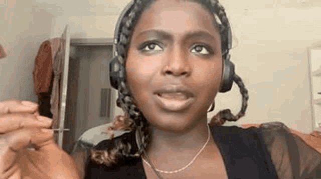 a woman wearing headphones and a necklace is holding a needle .