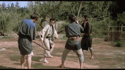 a group of men are fighting each other with swords in a movie scene .