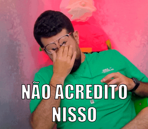 a man wearing glasses and a green shirt is covering his face with his hand and the words nao acredito nisso are below him