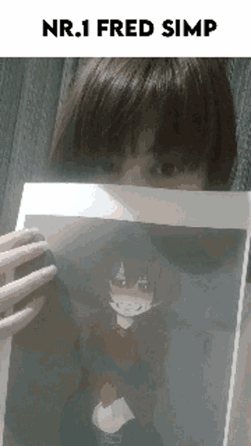 a girl is holding up a picture of a girl with a mask on her face .