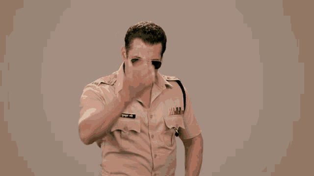 a man in a police uniform is covering his face