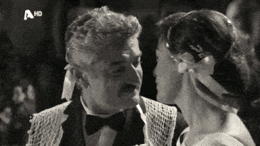 a black and white photo of a man and a woman with a hd logo on the bottom left