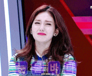 a woman making a funny face with a sign in the background that says ' seoul mummy '