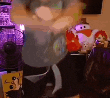 a blurred image of a room with stuffed animals and a purple chair