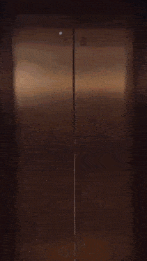 a woman in a black dress is standing in front of a mirror in an elevator